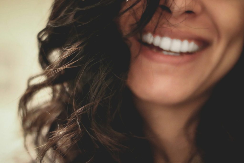 gros plan d'une femme aux longs cheveux noirs souriante